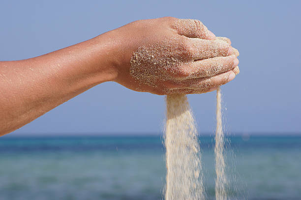 istock sand running through hands as a symbol for time running 514301993