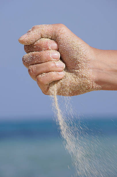 istock sand running through hands as a symbol for time running 514301997