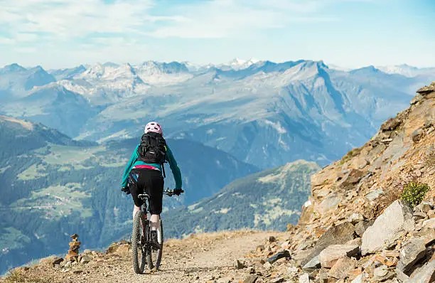 A female mountainbiker on her morning downhill high up above the village of Lenzerheide, Graubünden Canton, Switzerland.