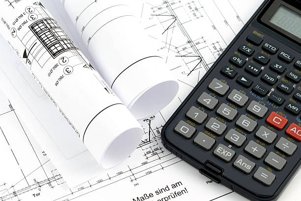 istock rolls of blueprints with a calculator 514310602