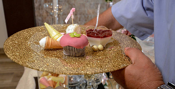 istock Male hand holding cupcakes and sweets in a platter 514311812