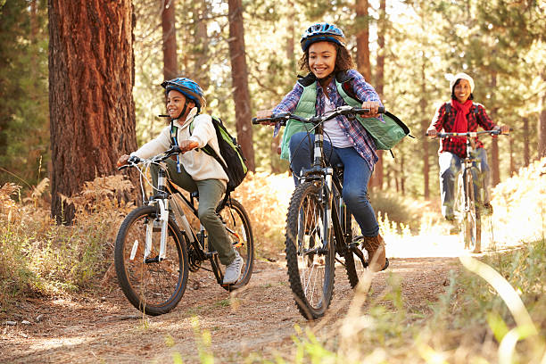 abuelos con niños ciclismo a través de bosques otoño - casco de deportes fotos fotografías e imágenes de stock