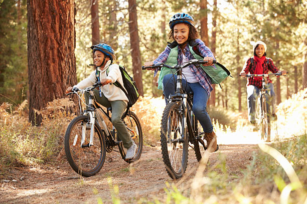 grands-parents avec enfants faire du vélo dans la forêt d'automne - mountain biking photos et images de collection