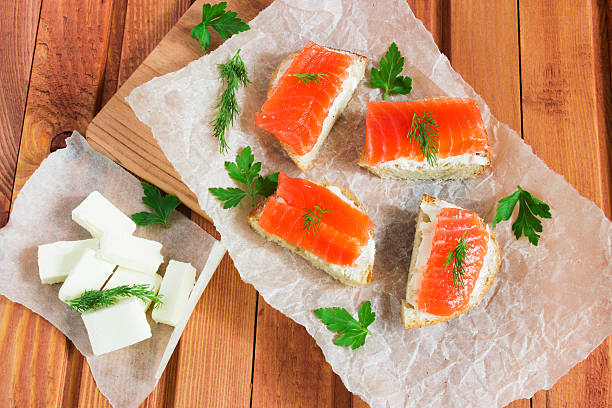 Sandwich with salted salmon and butter and spices Sandwich with salted salmon, butter, dill, parsley, and spices on wooden table sandwich new hampshire stock pictures, royalty-free photos & images