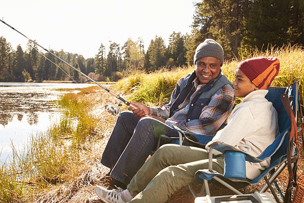 istock Grandfather Teaching Grandson To Fish By Lake 514312560