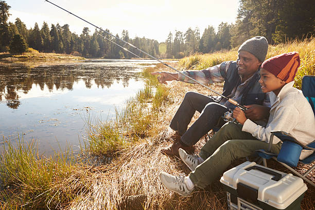 istock Grandfather Teaching Grandson To Fish By Lake 514312578