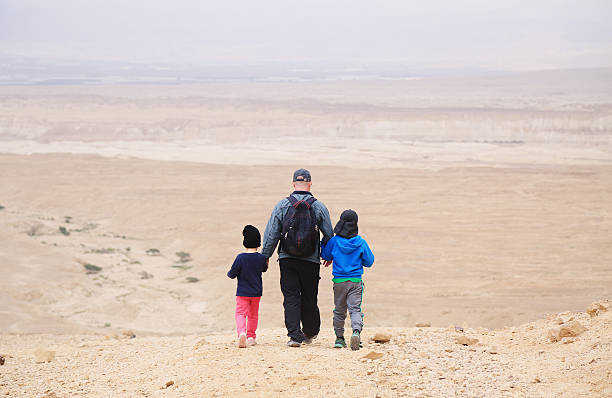 istock father hiking with two kids in the desert 514314070