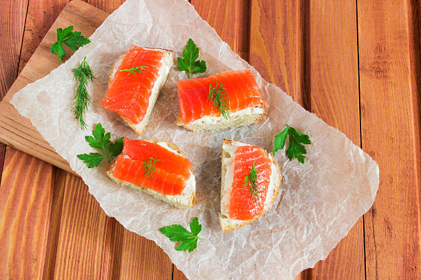 Sandwich with salted salmon and butter and spices Sandwich with salted salmon, butter, dill, parsley, and spices on wooden table sandwich new hampshire stock pictures, royalty-free photos & images