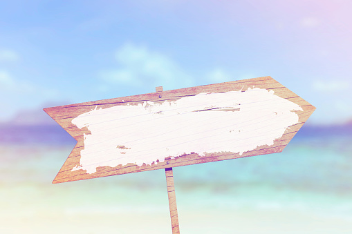 Blank wooden sign against summer beach background