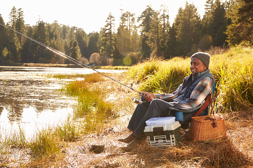 Senior African American Man Fishing By Lake