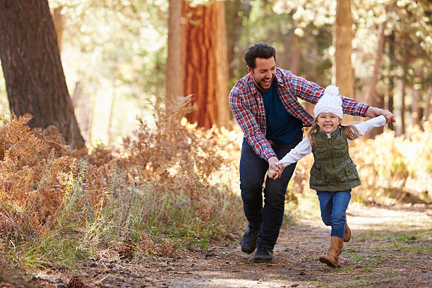 istock Father And Daughter Running Through Fall Woodland 514318608