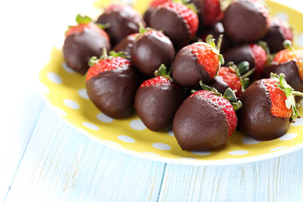 istock Fresh strawberries dipped in dark chocolate on blue wooden backg 514318706