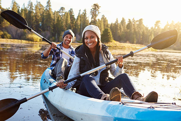 African American Couple Rowing Kayak On Lake African American Couple Rowing Kayak On Lake canoeing stock pictures, royalty-free photos & images
