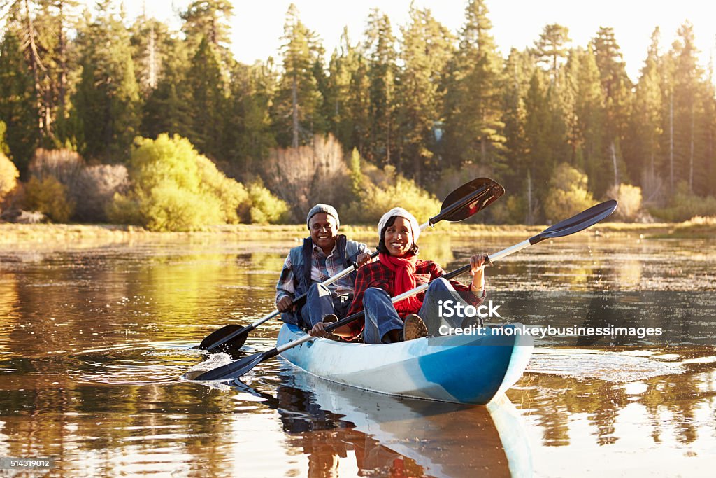 Senior African American Couple Rowing Kayak On Lake Senior Adult Stock Photo