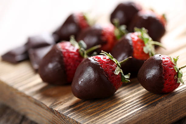 istock Fresh strawberries dipped in dark chocolate on grey wooden backg 514319396