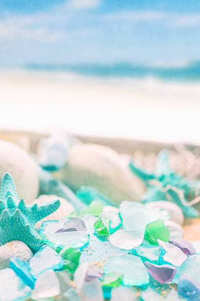 Green and white broken glass on the summer beach
