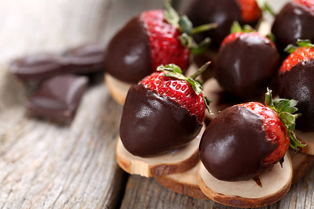 istock Fresh strawberries dipped in dark chocolate on grey wooden backg 514319836