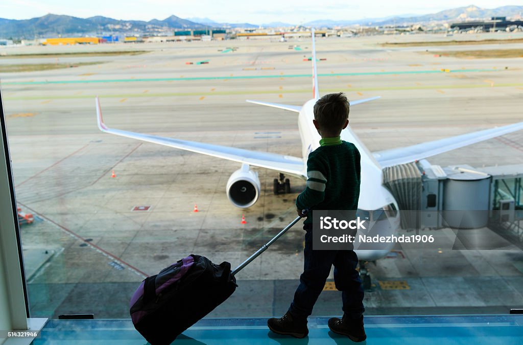 little boy with suitcase waiting in the airport little boy with suitcase waiting in the airport, kids travel Airplane Stock Photo