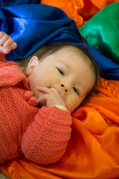 baby girl with colourful sensory material