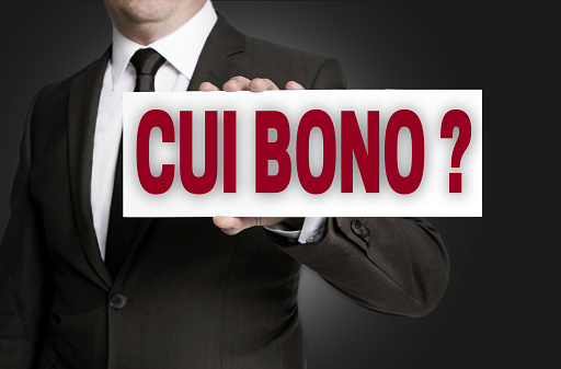 cui bono sign is held by businessman background.