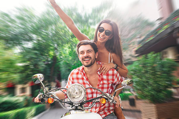 istock Couple smiling and riding a white scooter 514324102