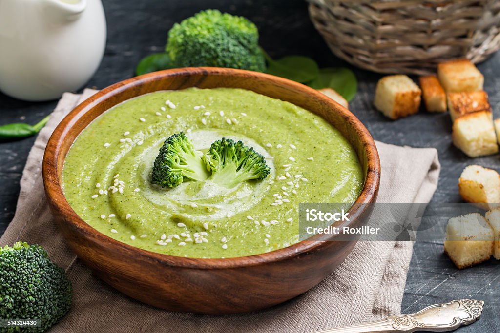 Broccoli cream soup Wooden bowl of broccoli cream soup on black table Appetizer Stock Photo