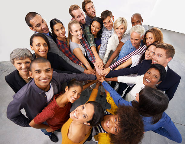 United we stand Shot of a diverse group of business people joining their hands in a symbol of unity organized group photos stock pictures, royalty-free photos & images