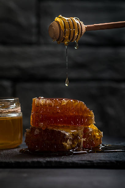 istock Honey dripping from a wooden honey dipper 514326450