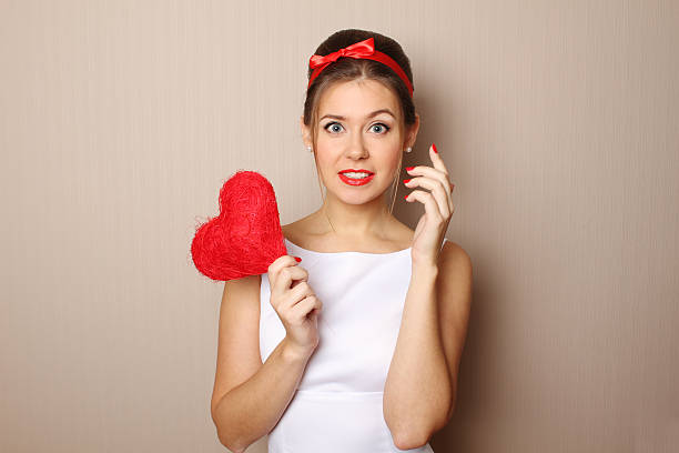 istock Beautiful young woman holding a red heart 514326810
