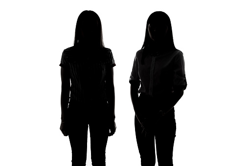 Silhouette of two young women on white background