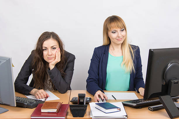 istock woman sitting table in frustration, other happily looking computer screen 514327782