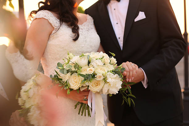 istock Bride and groom holding hands with bridal bouquet 514329676