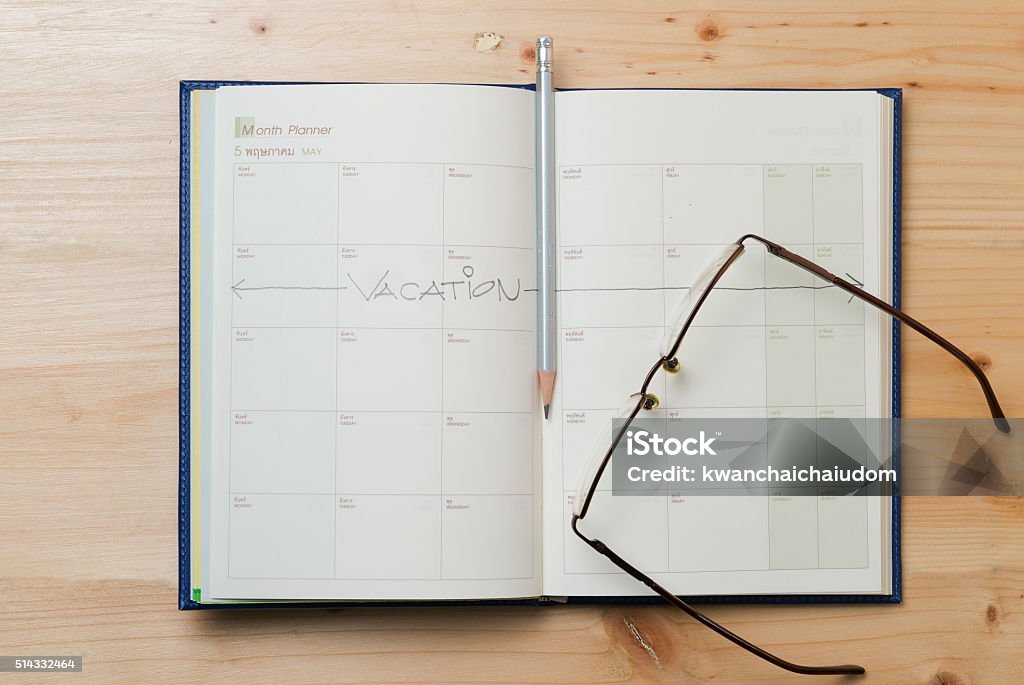 Vacation plan written on calendar Vacation plan written on calendar by a pencil on wood background Leaving Stock Photo