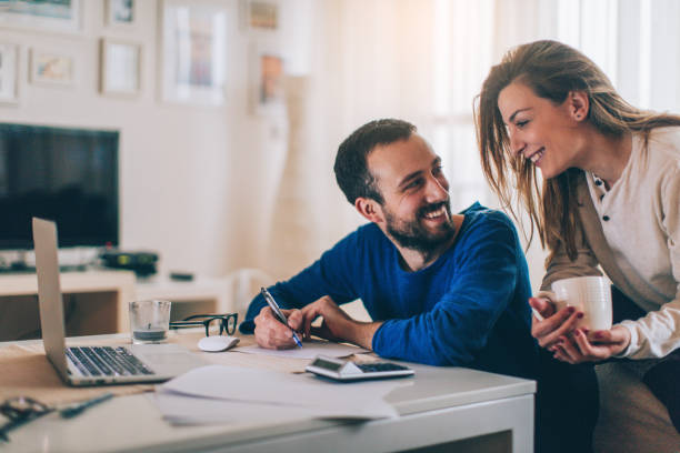 Checking our finances Couple sitting in their living room and checking their finances bank account stock pictures, royalty-free photos & images