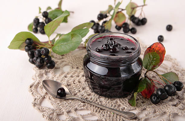 Black chokeberry jam in glass jar Black chokeberry jam in a small glass jar Aronia berry stock pictures, royalty-free photos & images