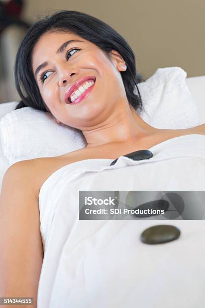 Happy Spa Customer Smiling During Cold Stone Therapy Relaxation Treatment Stock Photo - Download Image Now