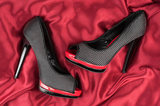 istock High-heeled shoes lying on red fabric 514360921