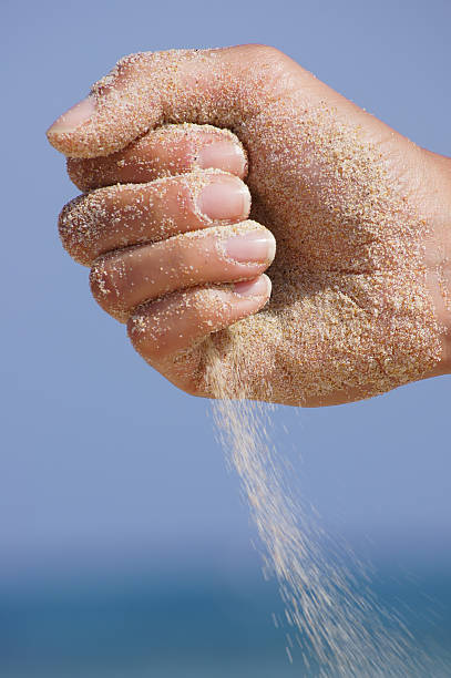 istock sand running through hands as a symbol for time running 514362257