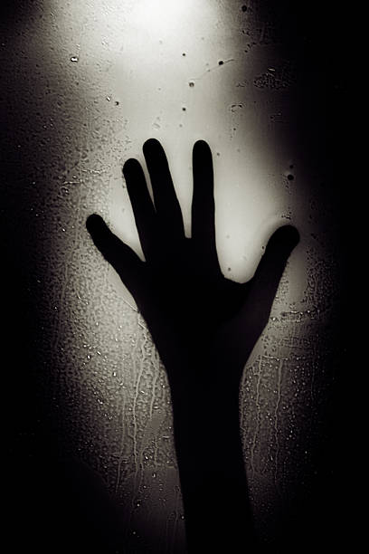 istock Black and White Dramatic Hand Shadow Behind Wet Glass 514363341