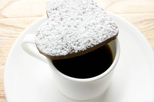Chocolate heart cookies in powdered sugar in a coffee cup