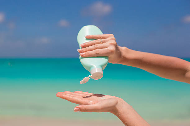 istock Woman hands putting sunscreen from suncream bottle 514365283