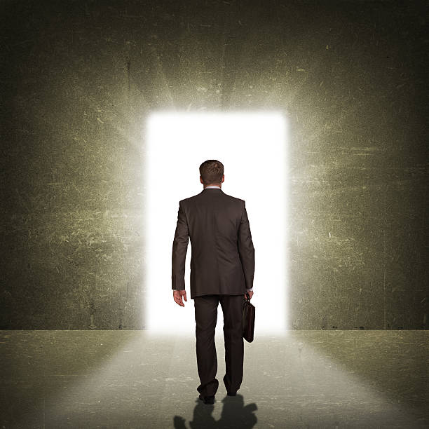 istock Businessman in suit with briefcase stepping through door 514366311
