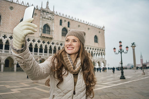 istock Woman tourist taking selfie with cell phone on St.Mark's Square 514367558
