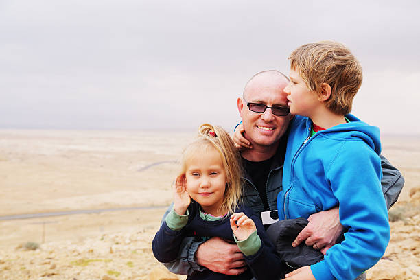 Portrait of father walking with two kids