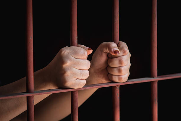Woman hand in jail hands of muslim woman holding bars in jail sharia stock pictures, royalty-free photos & images