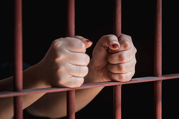 Woman hand in jail hands of muslim woman holding bars in jail sharia stock pictures, royalty-free photos & images