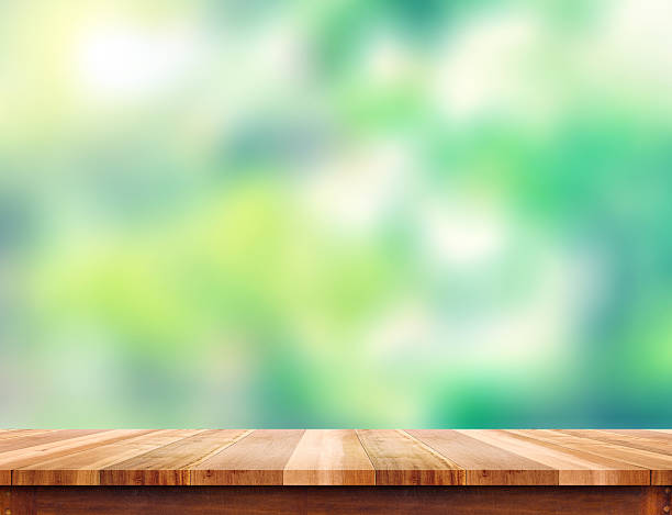 istock Empty plank brown wood table top with blur green tree 514370294
