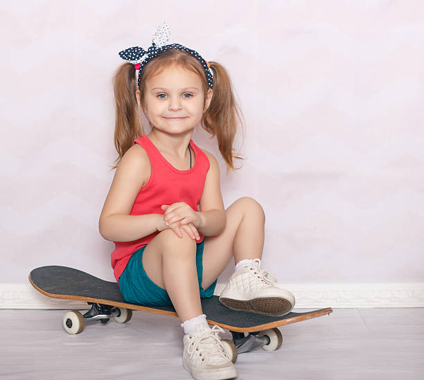 istock little girl with skateboard on light backgroundlittle 514372472