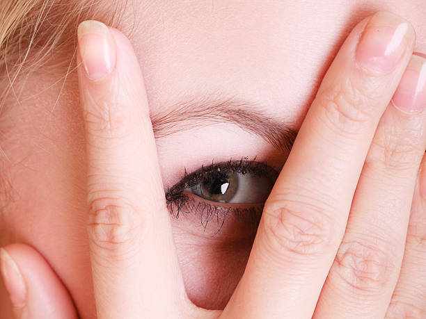 istock Closeup shy afraid woman peeking through fingers 514372664