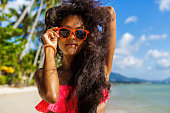 Beautiful black girl in skirt and bra on the beach.